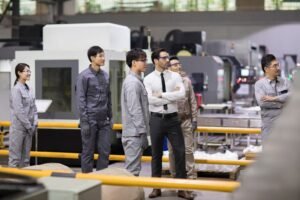 Confident businessman and engineering team in the factory
