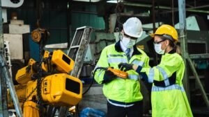 Industrial engineer in suite and safety helmet working in factory, planning and training